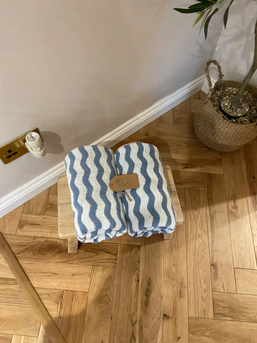 Folded striped towels set out on a wooden stool