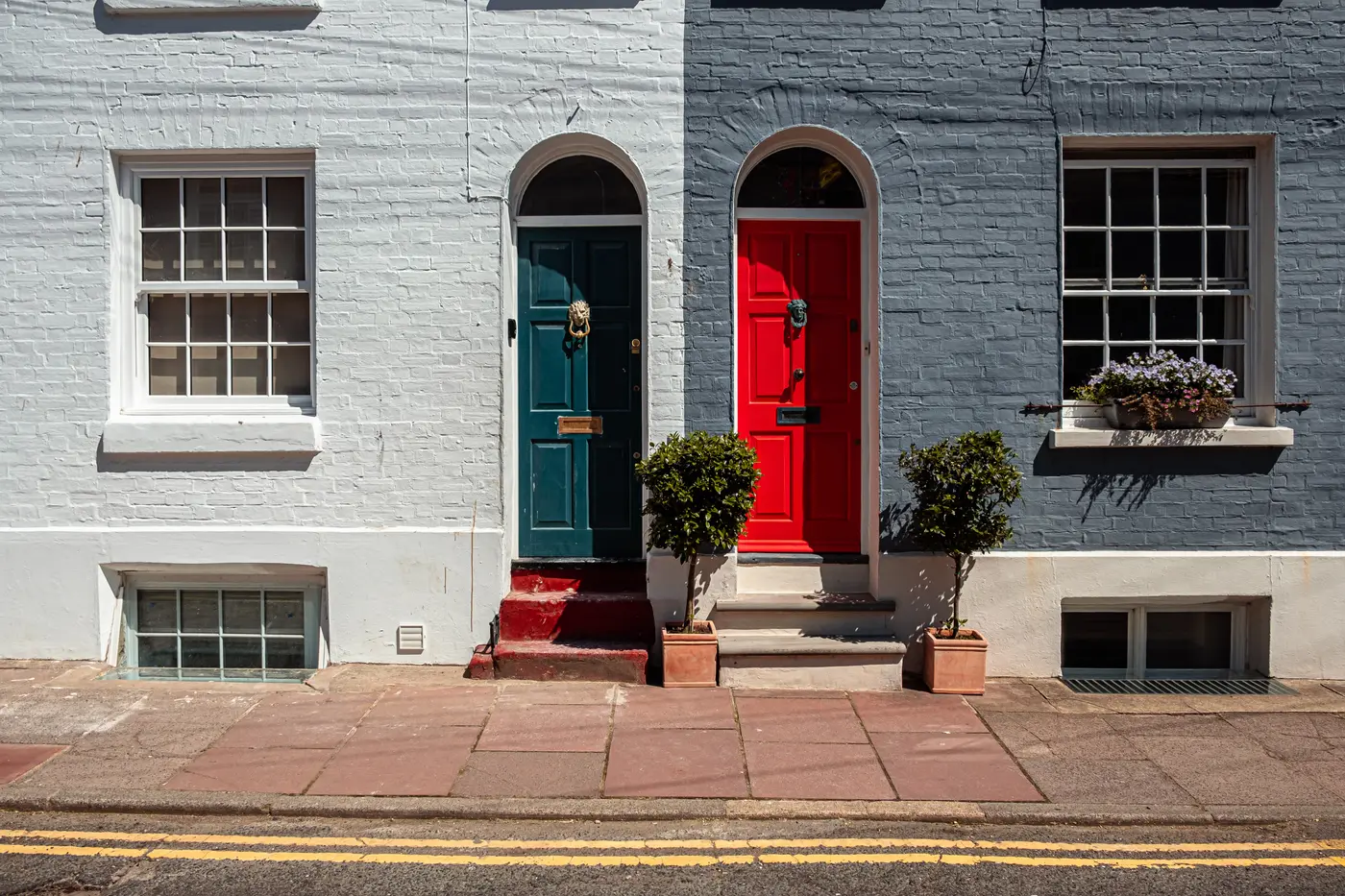 Row of painted terraced houses with sash windows and coloured front doors
